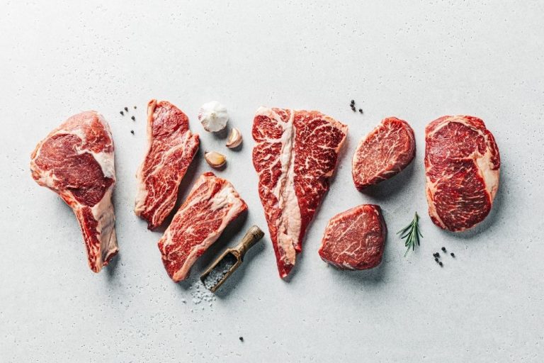Sept morceaux de viande présentés avec sel, échalotes et poivre sur une surface de préparation culinaire