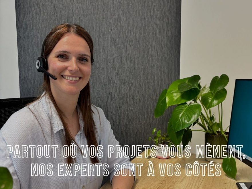 Salariée nommée Marion portant un casque de protection, souriante devant plusieurs écrans et un ordinateur dans un environnement de travail professionnel
